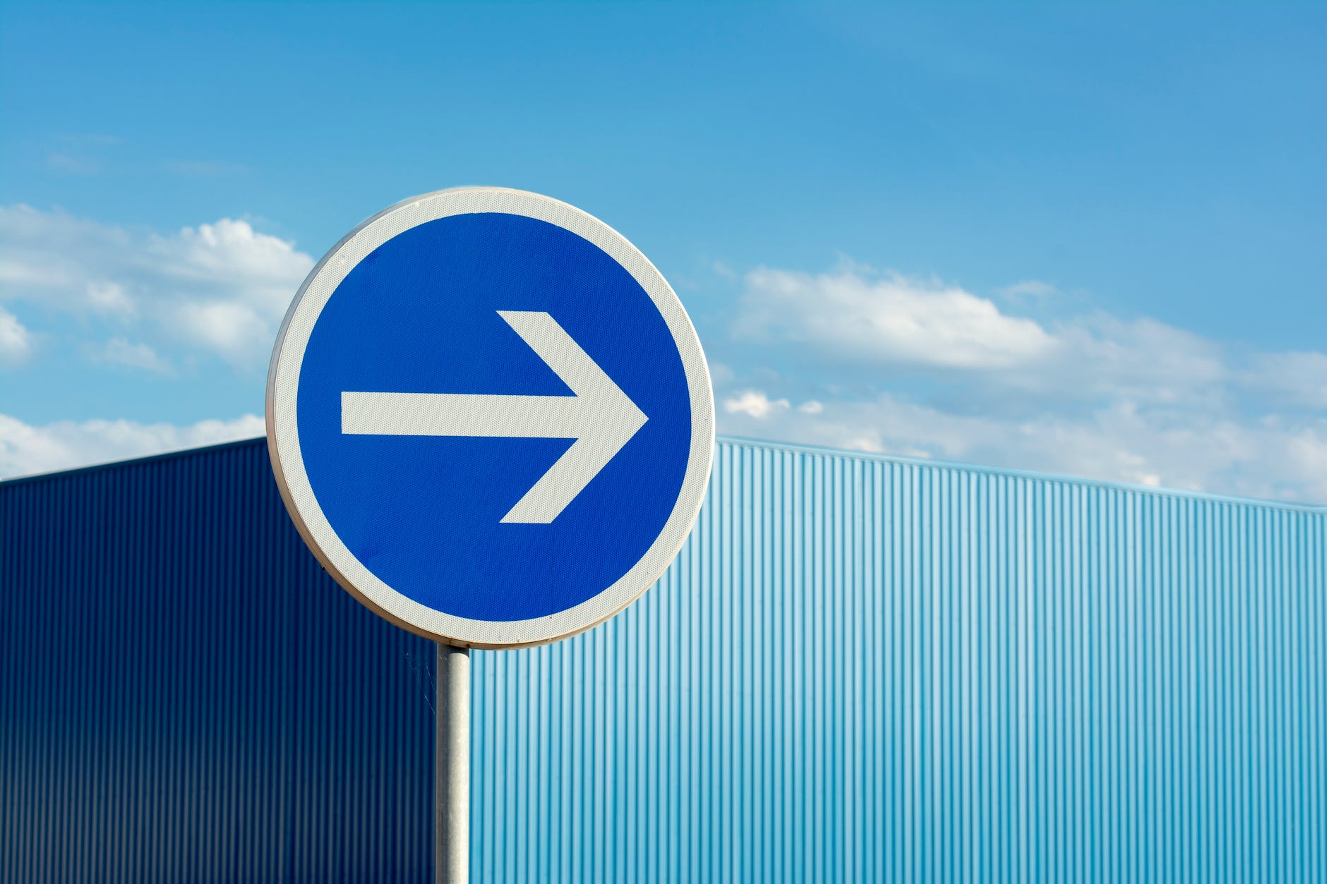 blue road sign with arrow