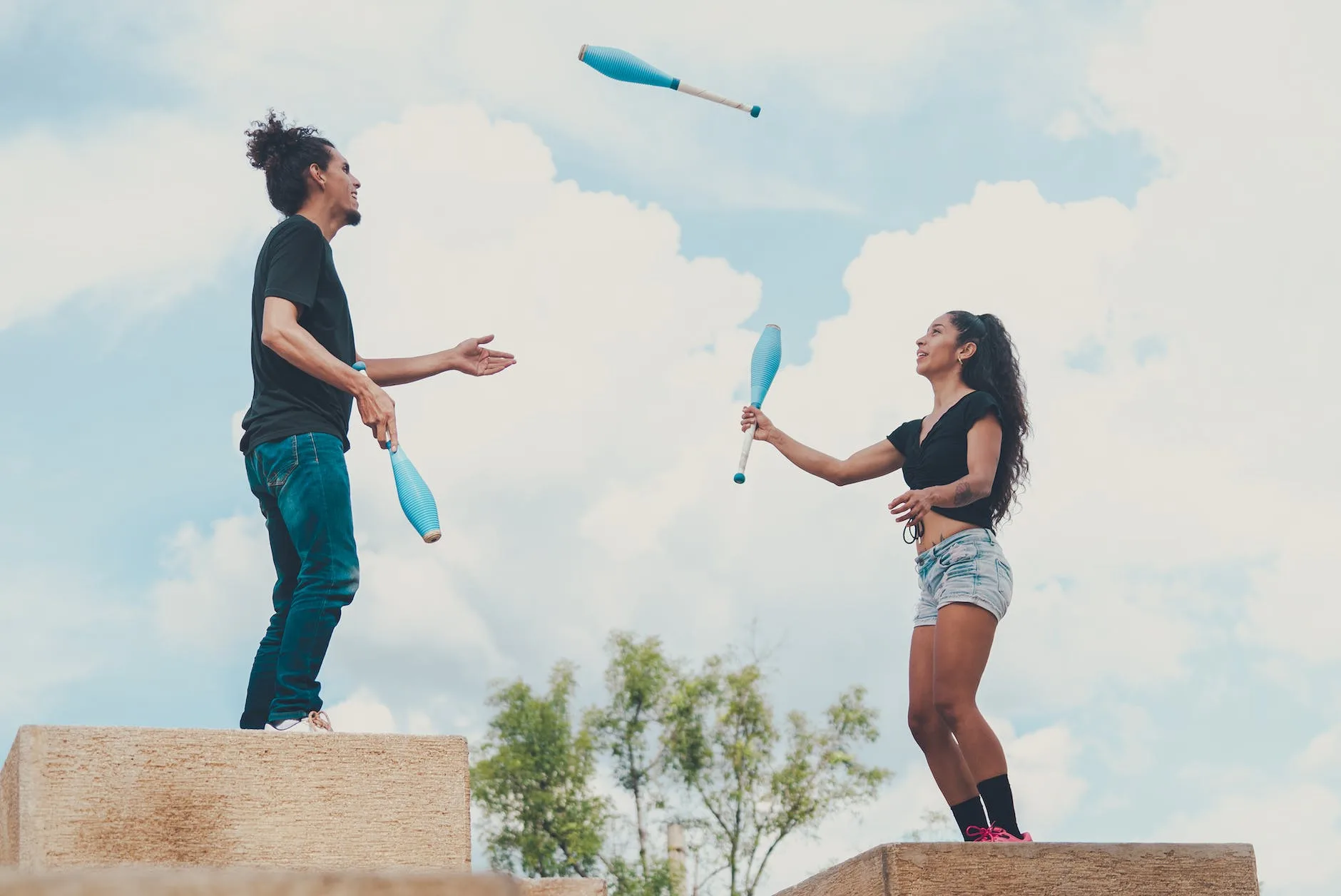 man and woman juggling together