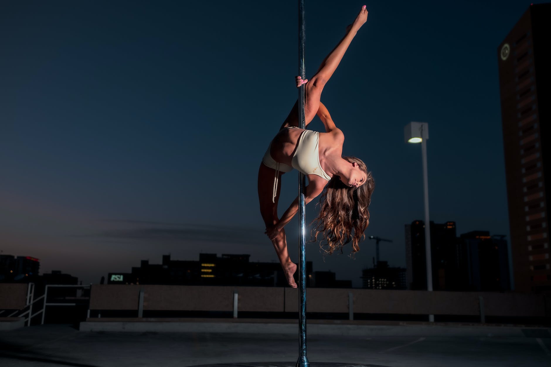 woman in white bikini doing pole dancing
