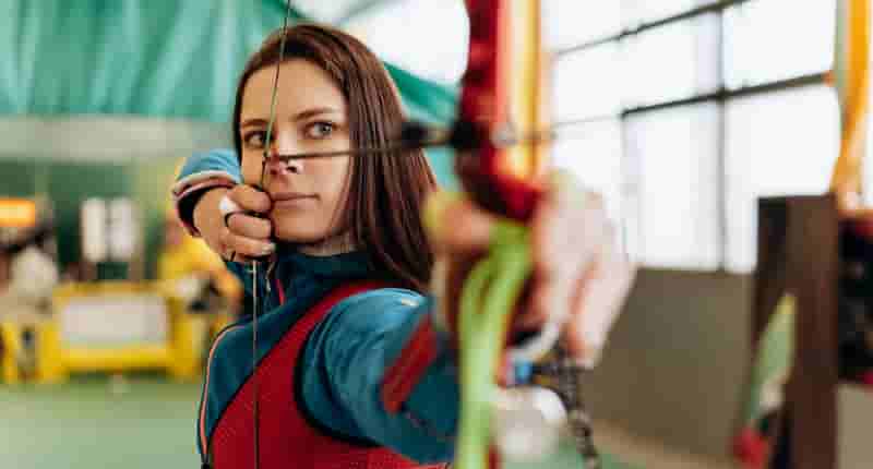 beautiful woman shooting a bow and arrow
