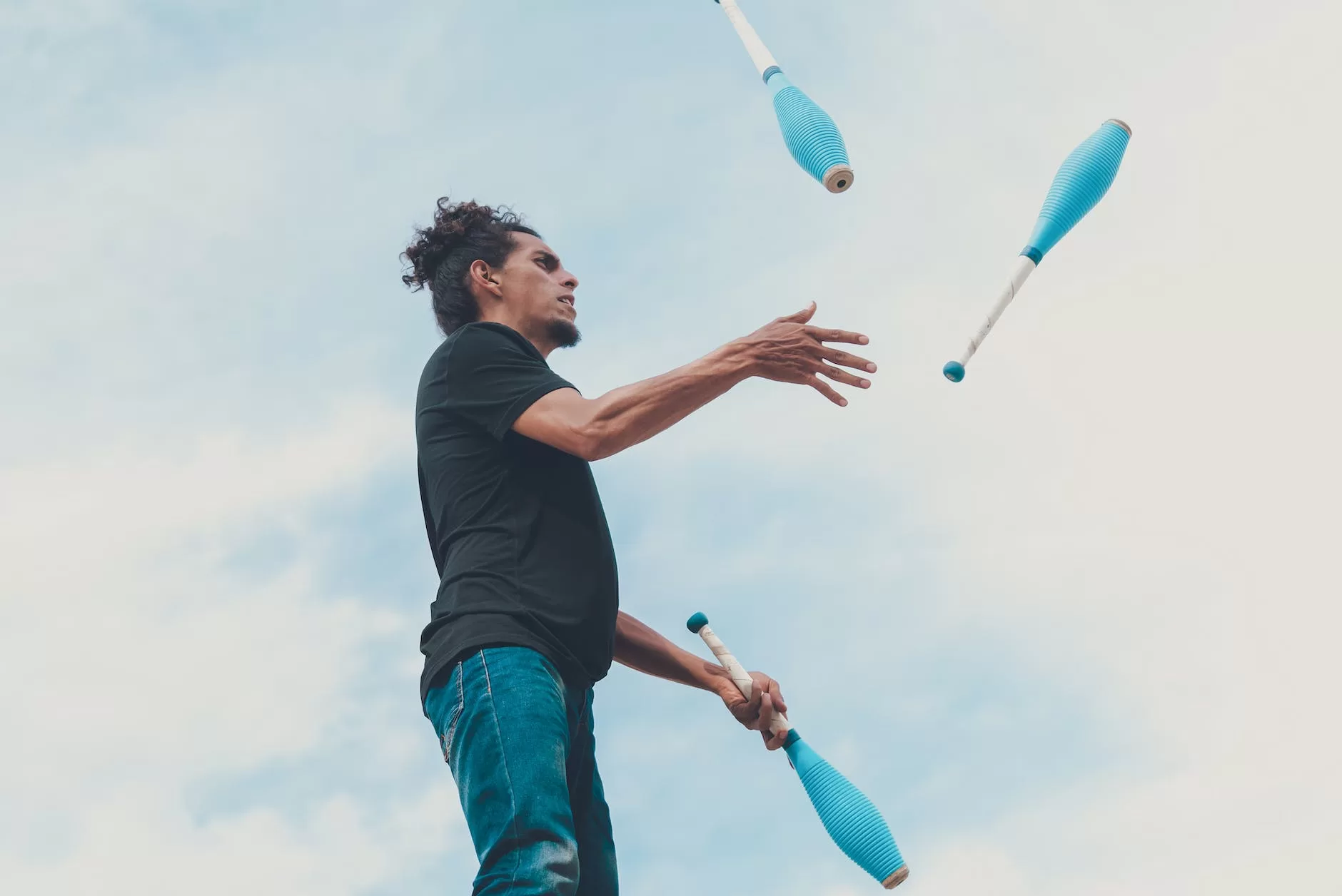 man in black t shirt and blue denim jeans juggling