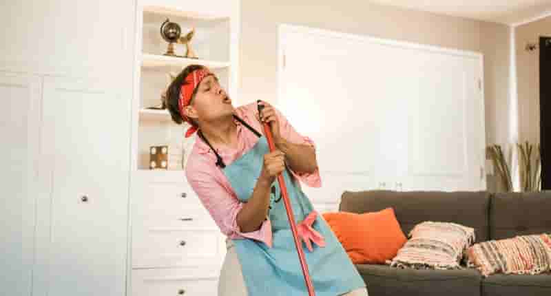 man pretending singing with a broom