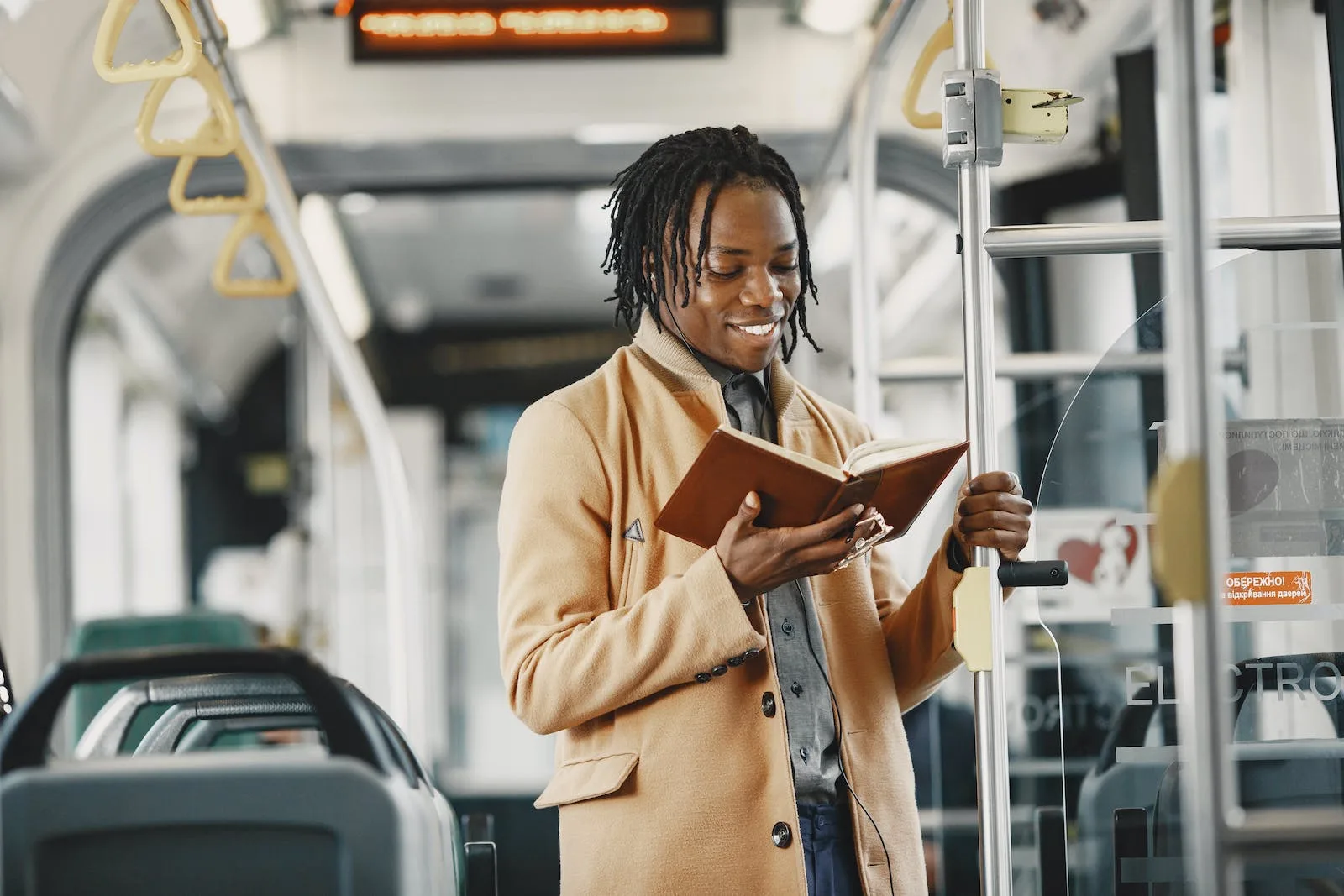 man reading book in public transport