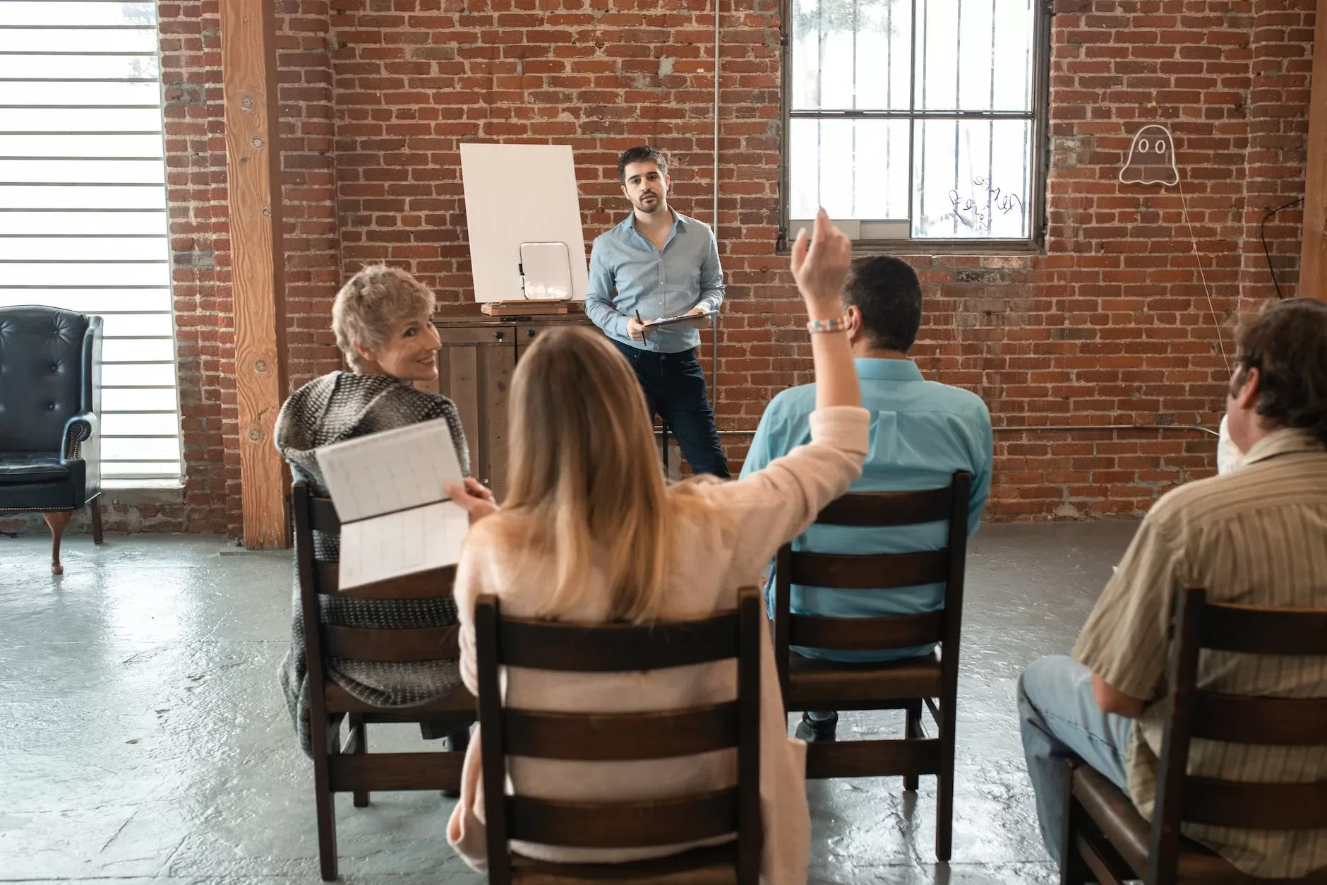 woman sitting at the back raising her hand