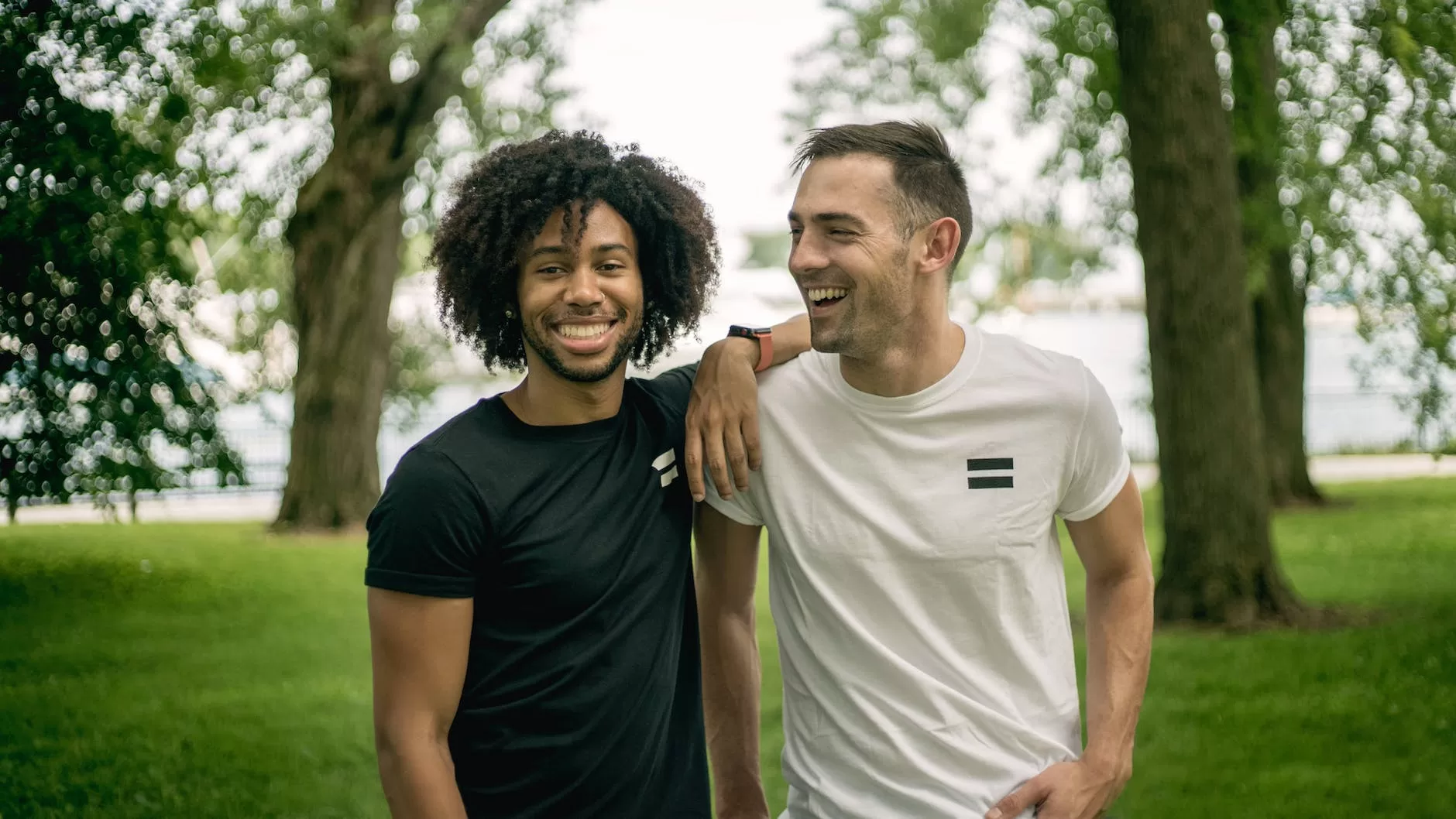 two men standing on grass field