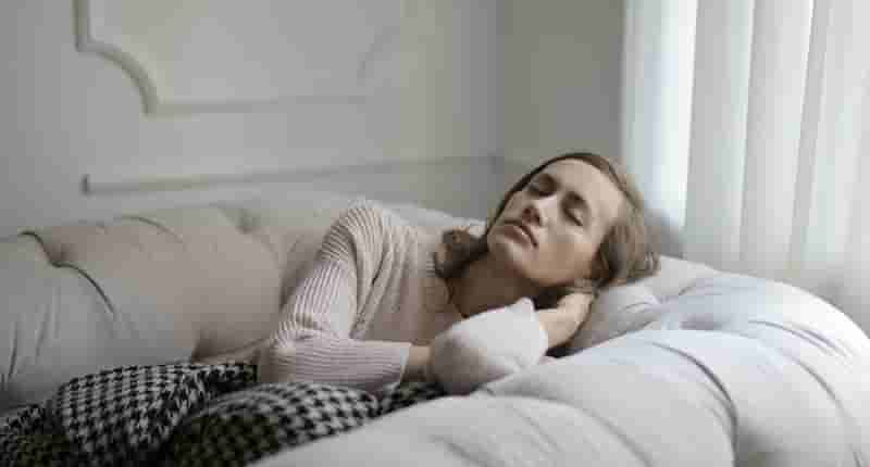 Girl in White Sweater Lying on Couch