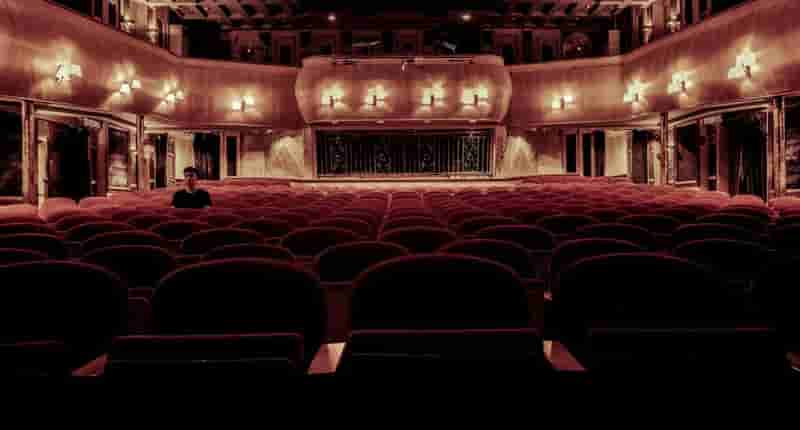 An elegant vintage theater with plush velvet seats and warm lighting, perfect for a serene cinematic experience.