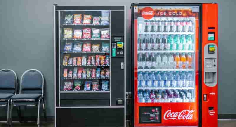 coca cola and coca cola bottles in black vending machine