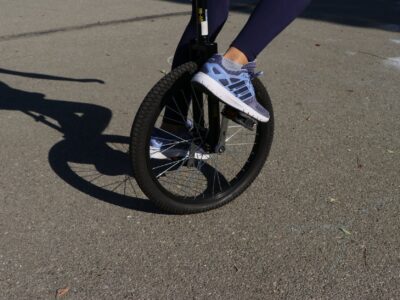 crop person riding unicycle on asphalt road