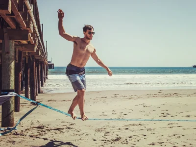 man standing on rope near beach