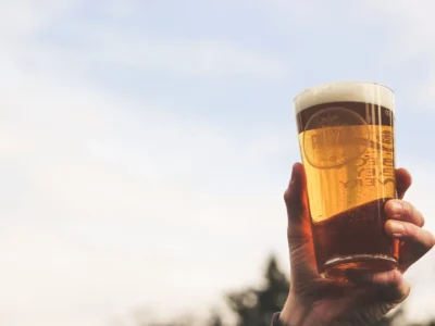 close up photo of person holding glass of beer
