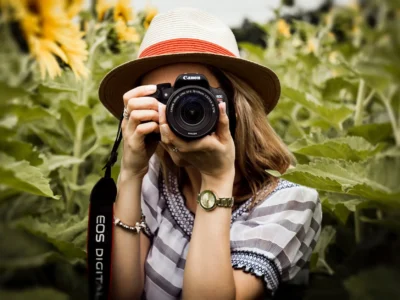 selective focus photography of woman holding dslr camera