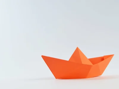 orange paper boat on white surface