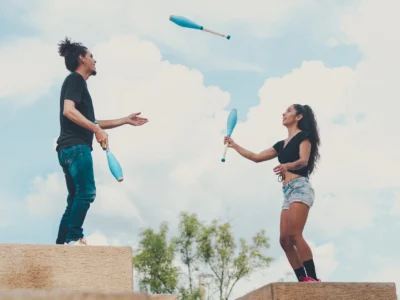 man and woman juggling together