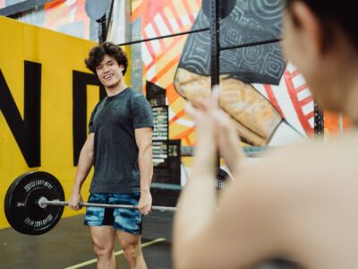 smiling athlete lifting barbell in gym