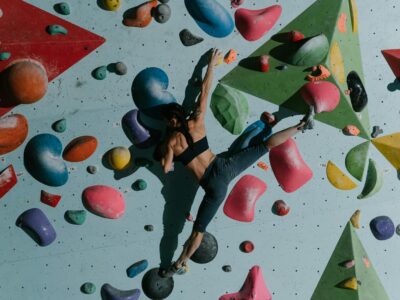 A Woman Climbing a Bouldering Wall