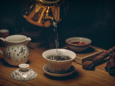 Artistic depiction of a traditional Chinese tea ceremony with porcelain teaware and hot water pour.
